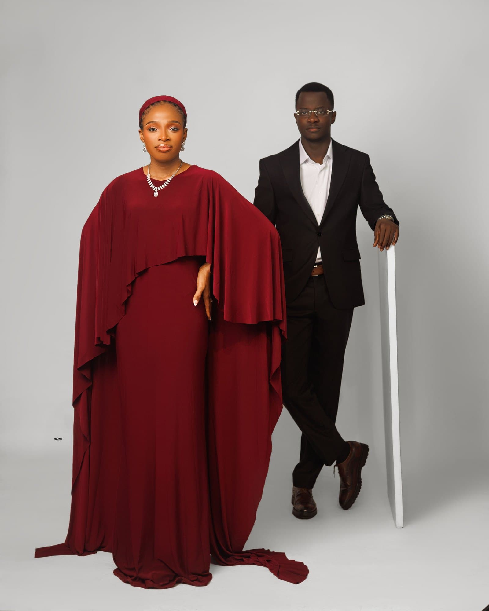 Scholarstica and Joseph in a grand burgundy cape gown and bespoke black suit